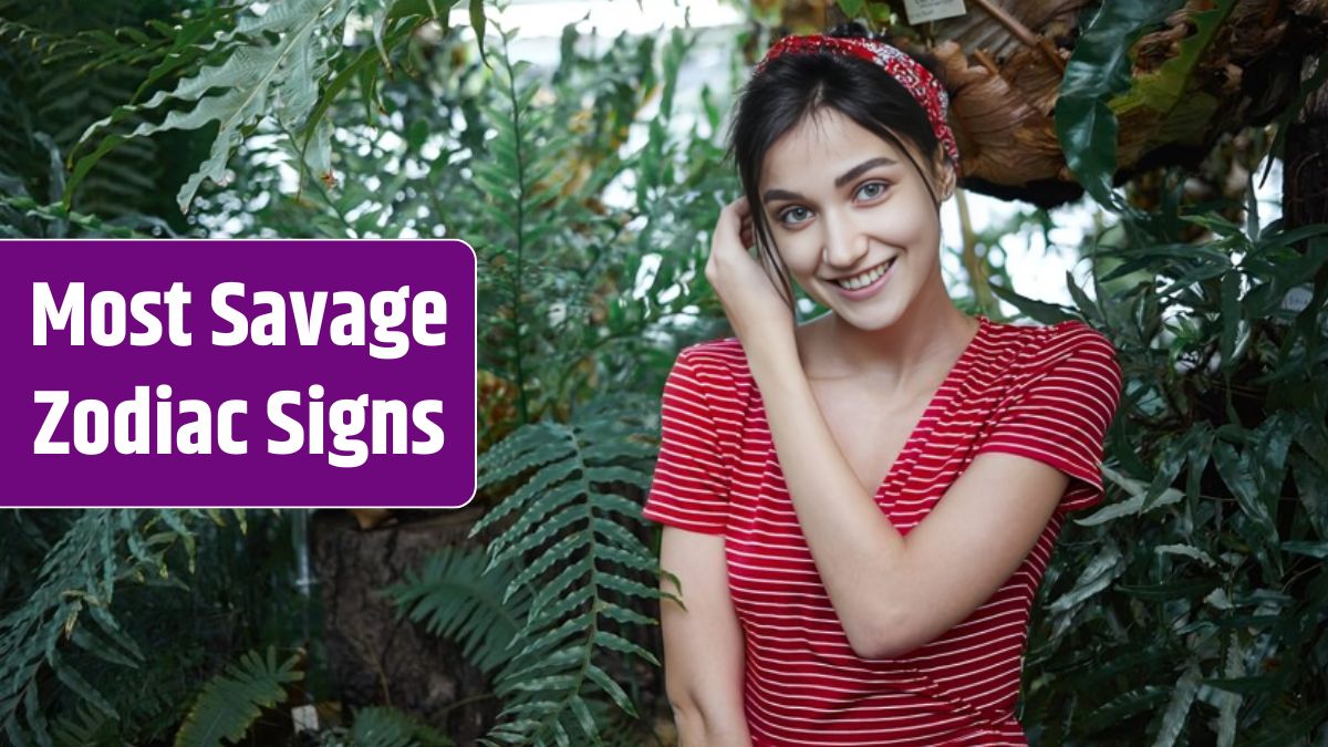 Picture of stylish brunette young European female in fashionable dress and headwear feeling happy and relaxed standing against big green leaves of exotic plants background, smiling broadly at camera.